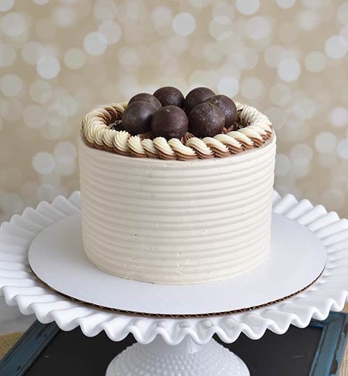 Buttercream cake with chocolate spheres on the top.