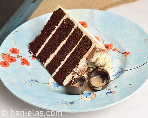 Slice of a cake with chocolate sphere broken showing the liquor filling.