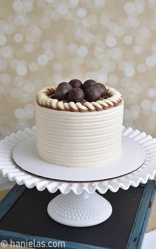 Buttercream cake with chocolate spheres on the top.