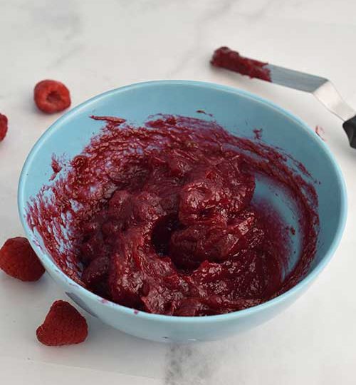 Raspberry cake filling in a bowl.