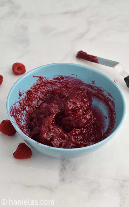 Raspberry cake filling in a bowl.