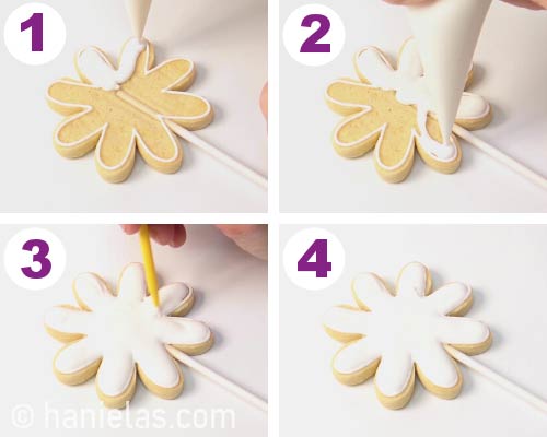 Outlining and flooding daisy cookie with royal icing.