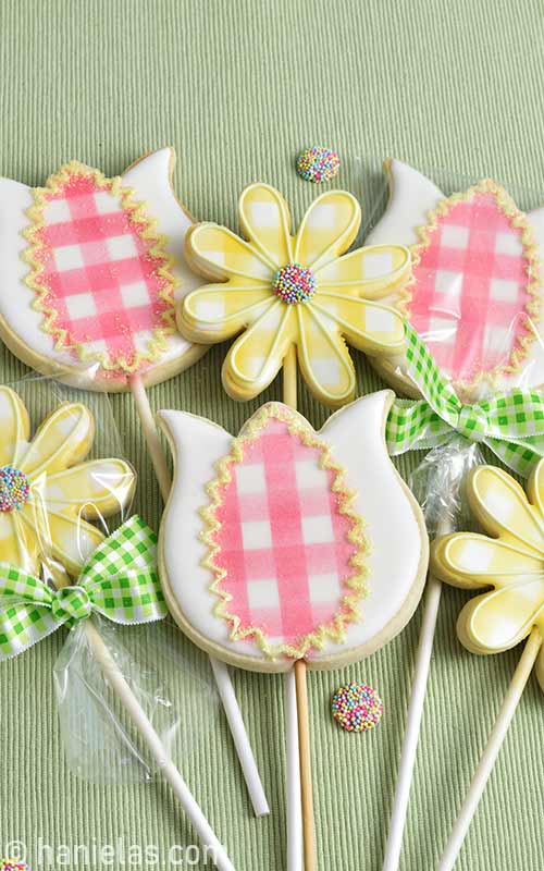 Decorated cookies on a stick arranged into a bouquet.