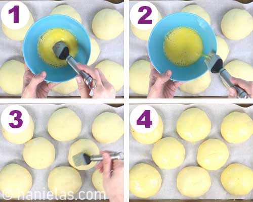 Brushing buns with egg wash.