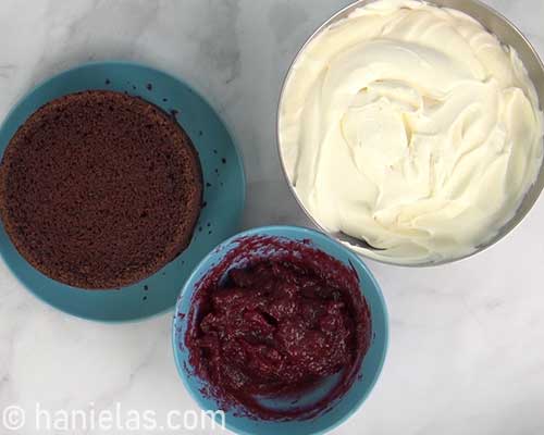 Cream cheese frosting and raspberry filling in bowls.