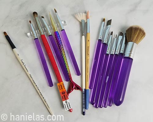 Variety of paint brushes laid out on a counter.