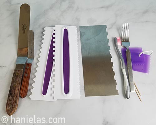 Spatulas and icing combs laid out on a table.