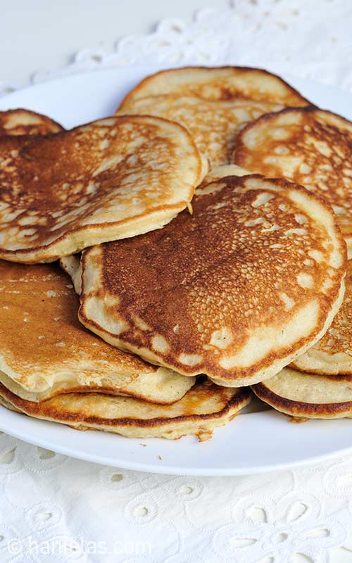 Close up of cooked pancakes stacked on a plate.