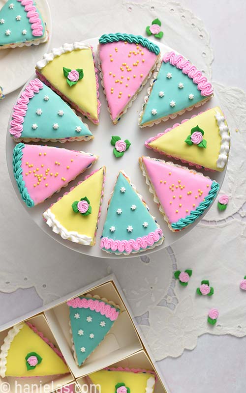 Decorated wedge cookies that look like little cakes on a cake stand.
