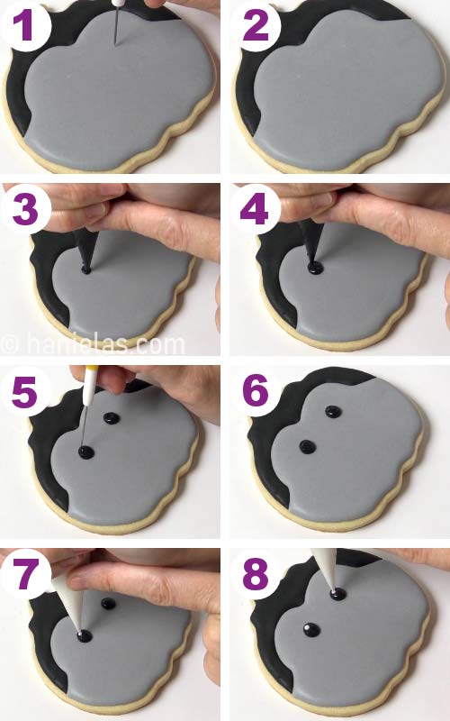 Piping black eyes onto a pumpkin cookie decorated like dracula.