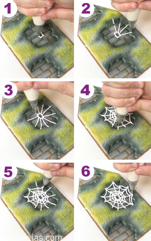 Piping white spider web onto a cookie.