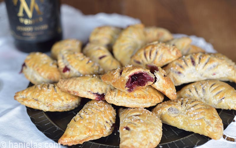 Baked hand pies on a black plate.