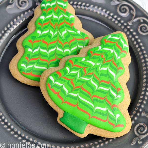 Tree cookie decorated with marbled wet on wet royal icing design.