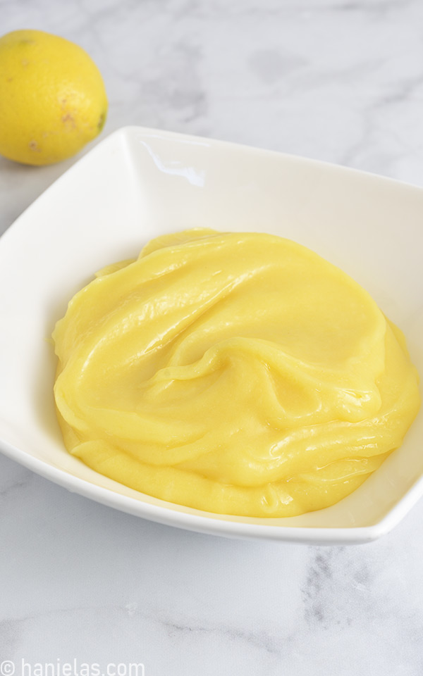 Yellow citrus curd in a white dish.