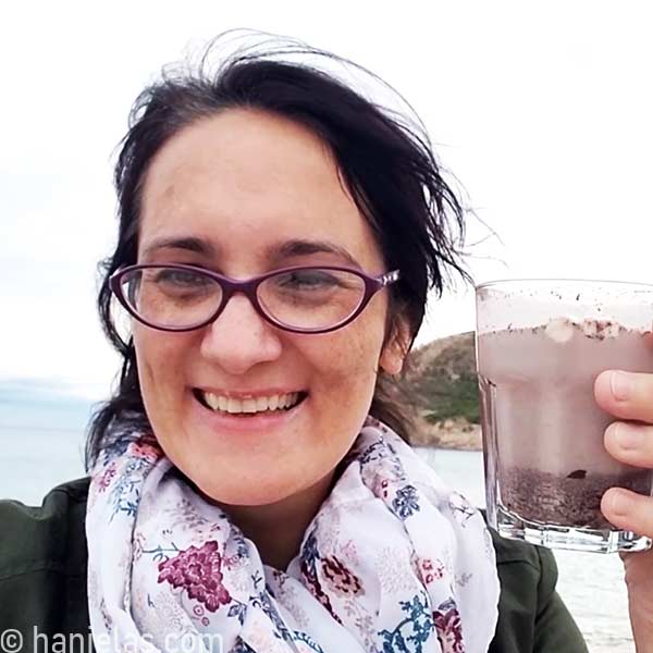 Woman holding a glass with hot chocolate drink.