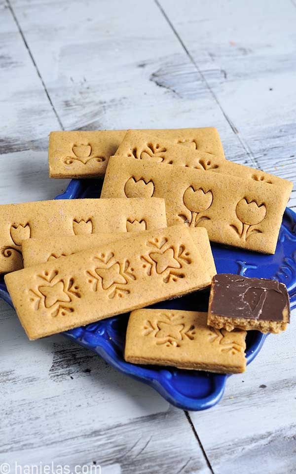 Cookies stamped with a decorative designs displayed on a blue plate.