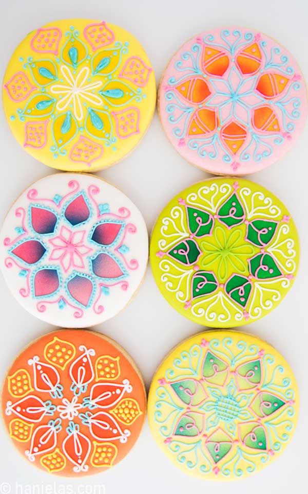 Colorful mandala inspired cookies on a white background.