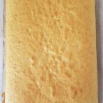 Baked yellow cake on parchment paper.