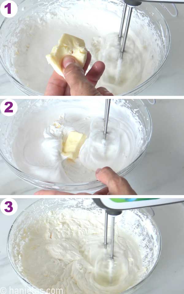 Beaters beating butter into the meringue in a glass bowl.