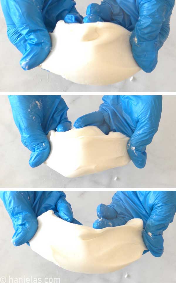 Hand stretching white fondant.