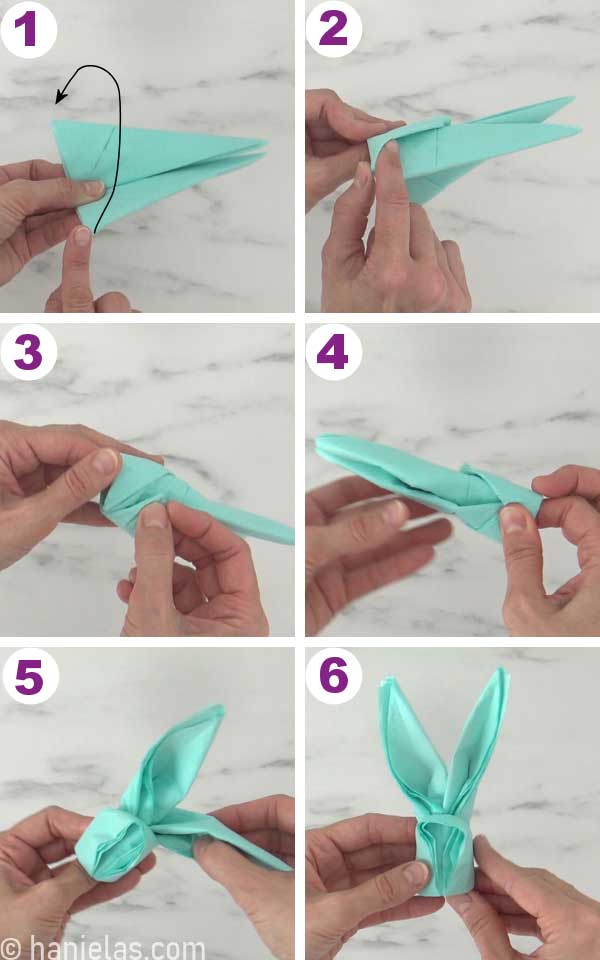 Tucking one end of the napkin under another to make a bunny,.