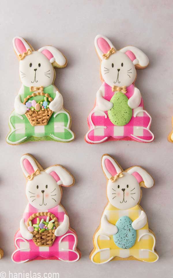 Pink, green and yellow sitting bunny cookies decorated with royal icing.