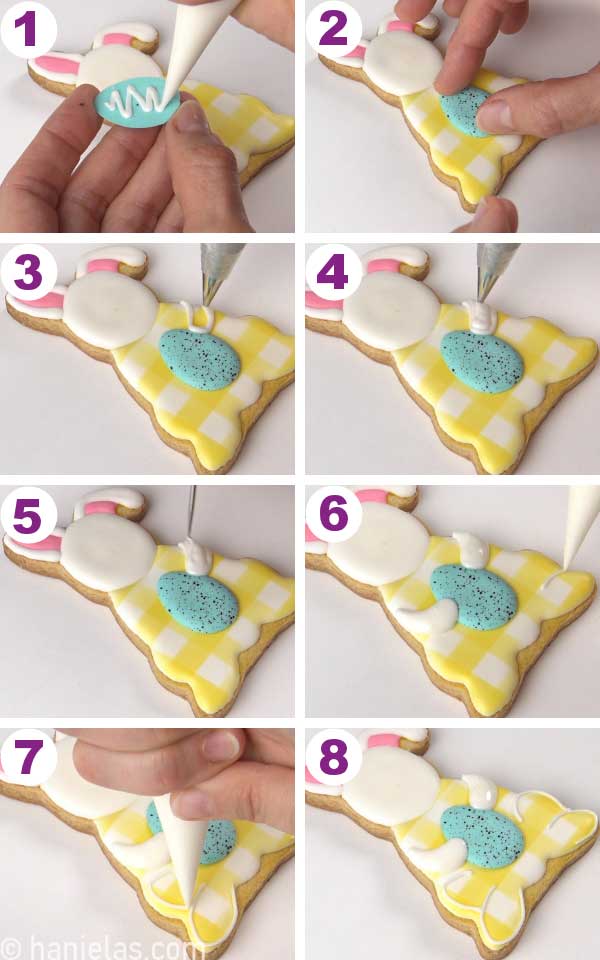 Hand holding a small royal icing egg, attaching it onto a sitting bunny cookie.