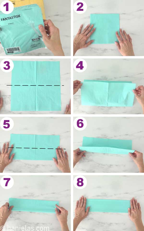 Hands folding the napkin in half.