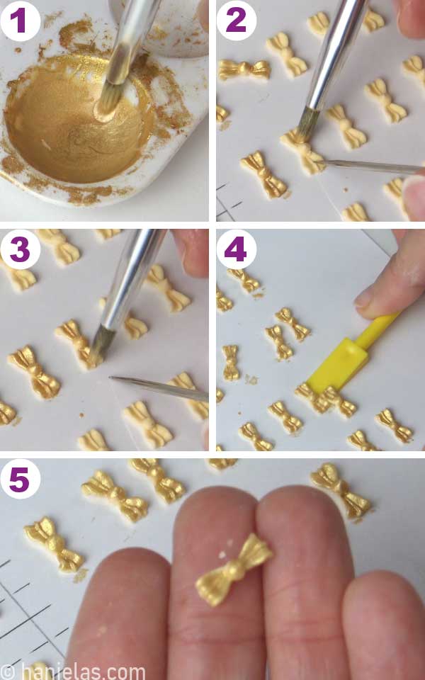 Gold luster dust paint in a small dish, paintbrush painting small royal icing bows.