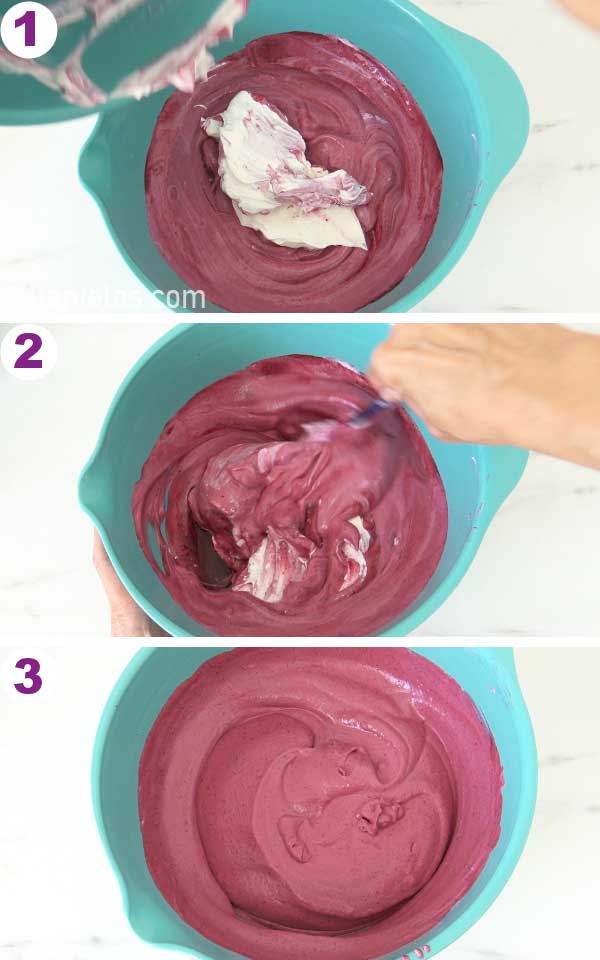 Spatula folding whipped cream into bright purple mousse.