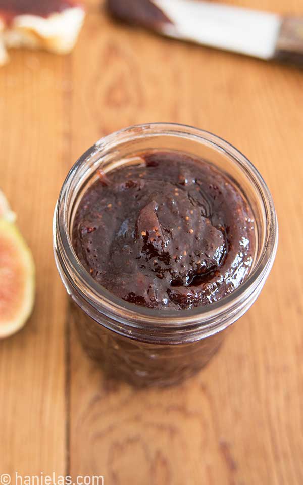 Glass jar filled with dark fig jam.