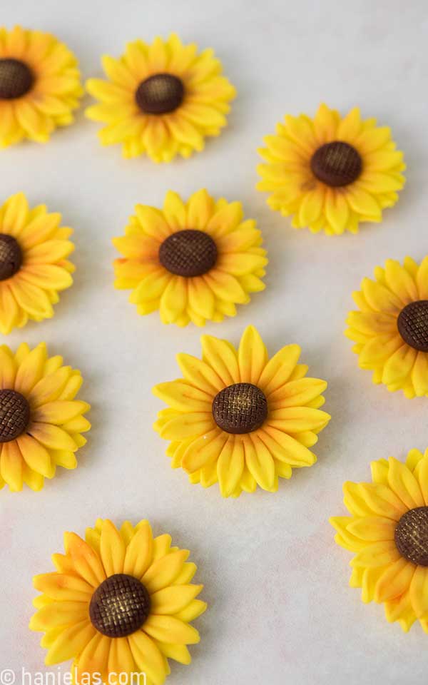 Dry yellow fondant flowers on a light pink background.