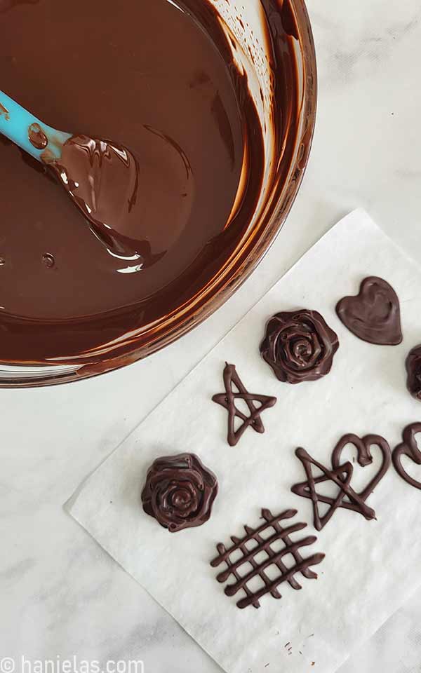 View from the above, parchment paper with piped chocolate decorations.