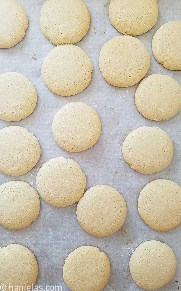Freshly baked and naked cookies on a baking sheet lined with parchment.