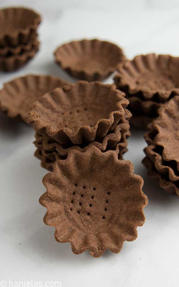 Stacked small tart shells on a counter.