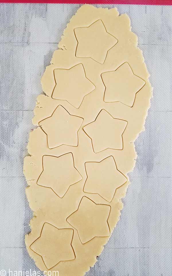 Rolled out cookie dough with star cutouts.
