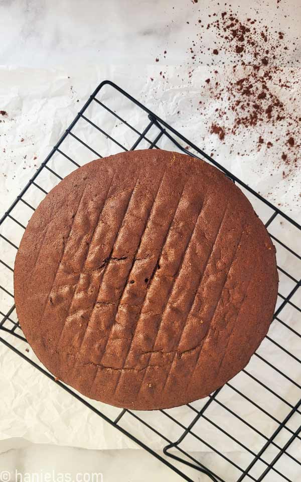 A baked cake on a black cooling rack.