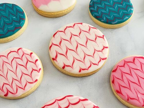 Close-up of a round cookie decorated with white and red icing.