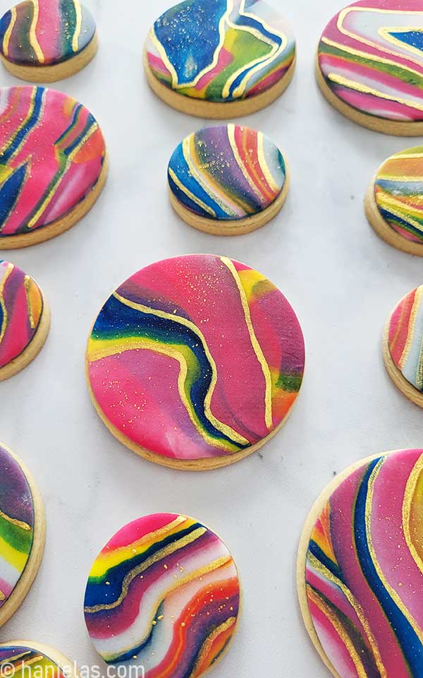 Close-up of cookies decorated with colorful icing and edible gold paint.