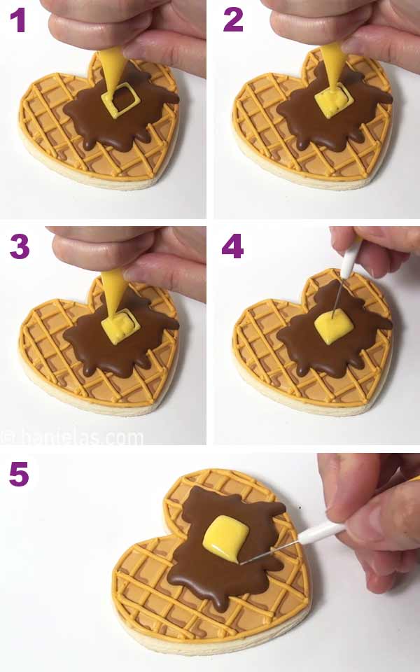 Piping bag piping yellow square shape onto a waffle cookie.