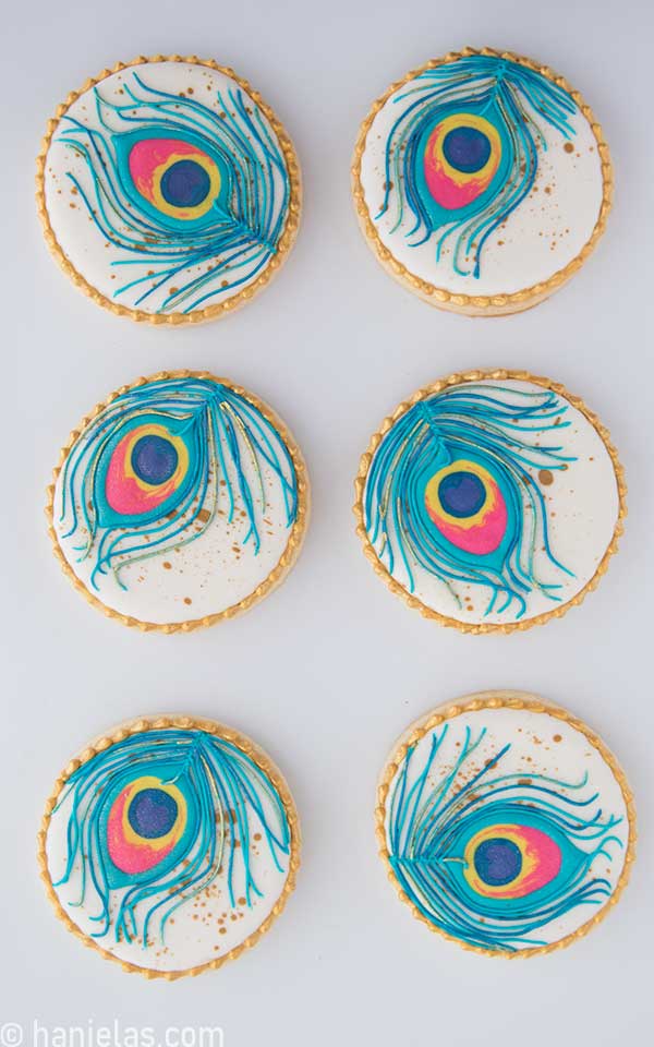 View from the above, six round cookies decorated with icing.