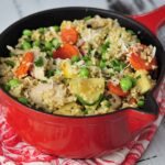 Small cast iron pot with cooked millet, meat and vegetables.