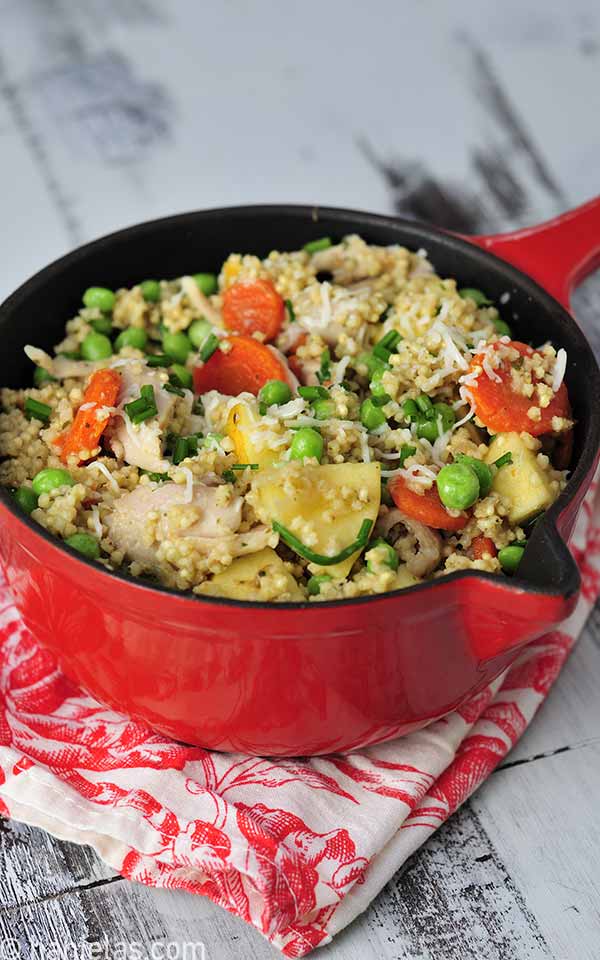 Small cast iron pot with cooked millet, meat and vegetables.