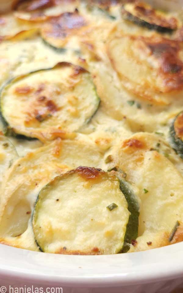 A close of up baked, golden brown zucchini and potato slices.