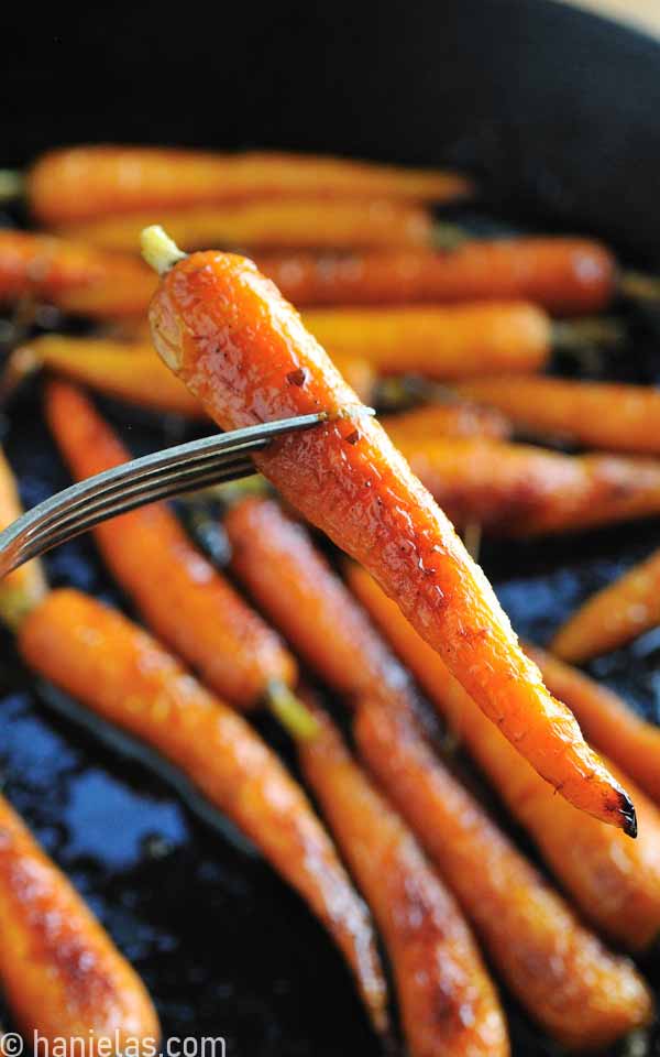 Fork holding a roasted carrot.