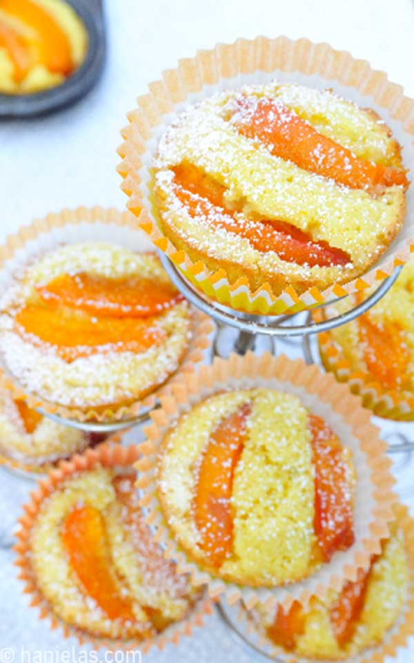 Baked muffins in orange liners in a muffin stand.