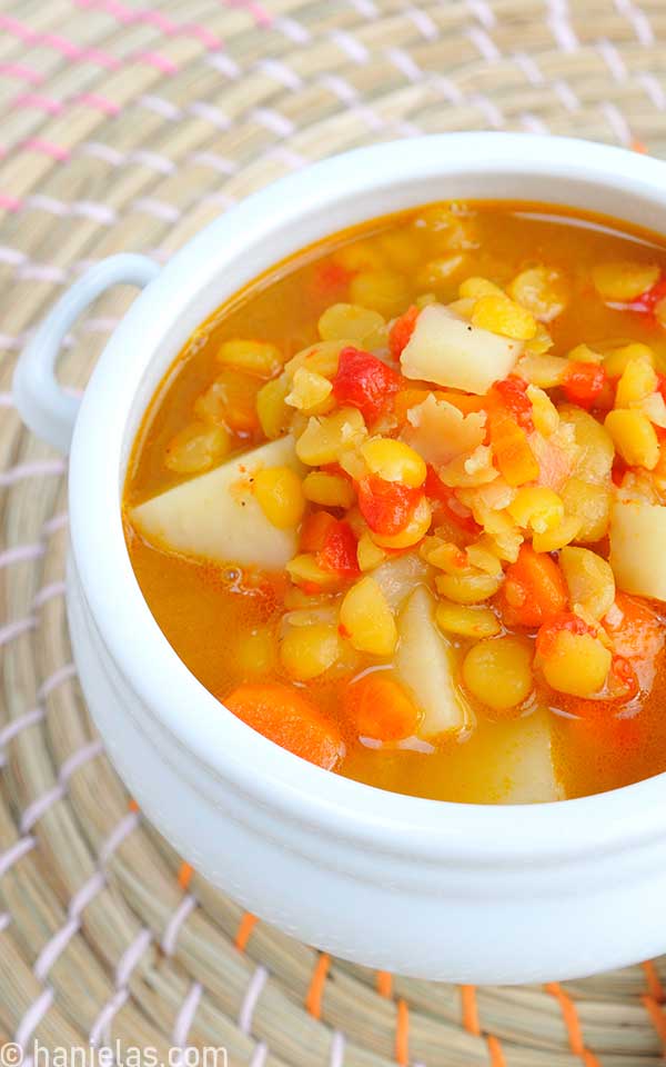A close up of split pea soup with red pepper.