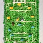 A view from above showing green no bake cereal soccer field cake with white chocolate goals and chocolate LEGO players.
