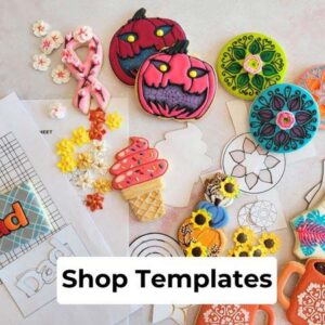 Decorated cookies and cardstock template on a marbled slab.