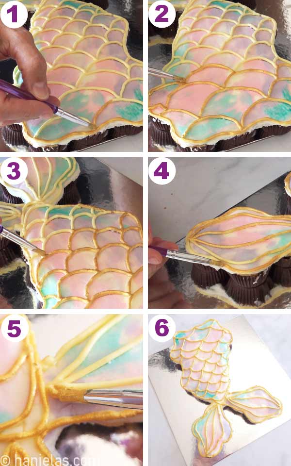 A paintbrush painting piped buttercream mermaid scales with gold edible paint.